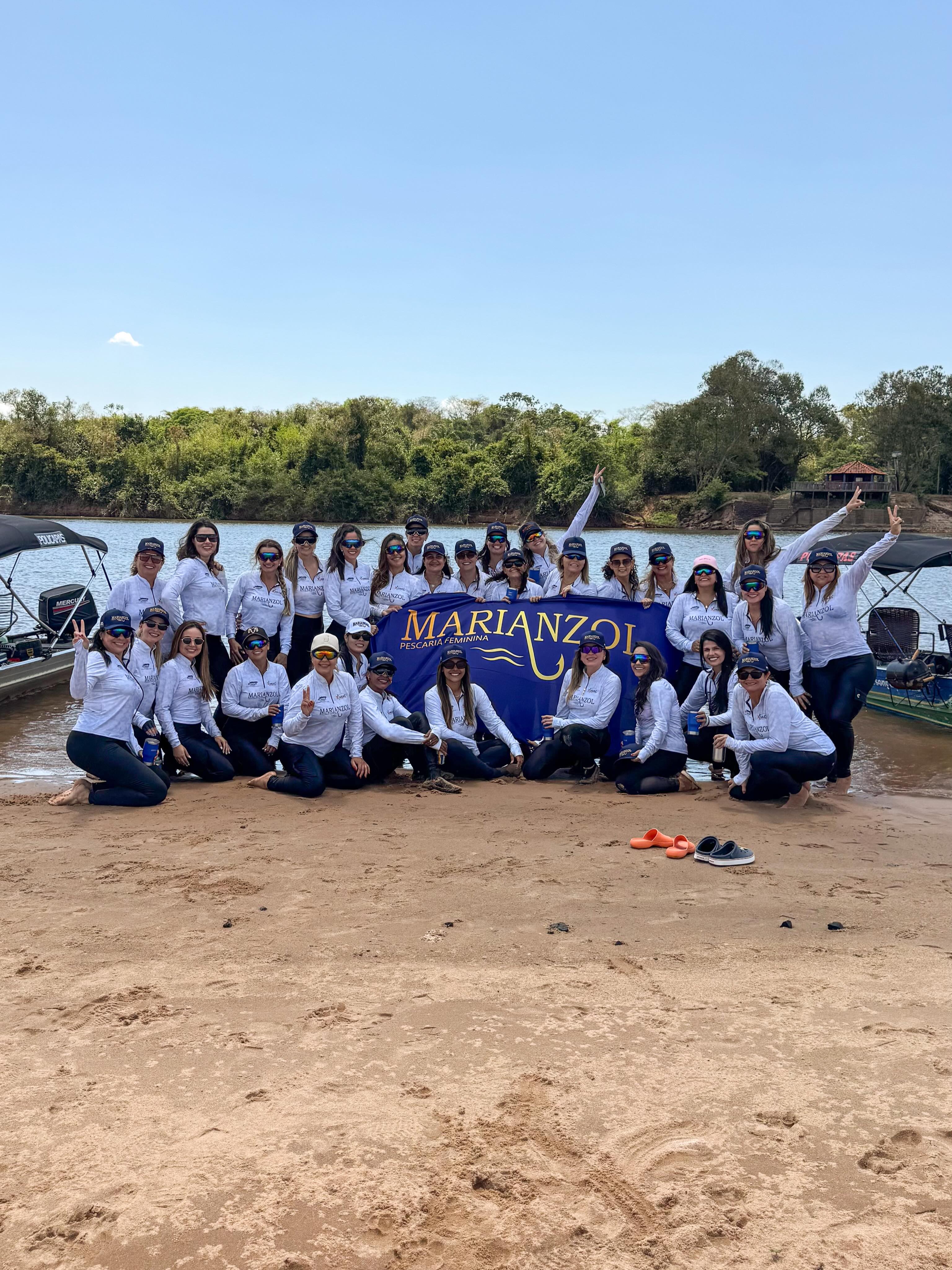 Grupo de mulheres da Marianzol reunido na praia do rio após a pescaria